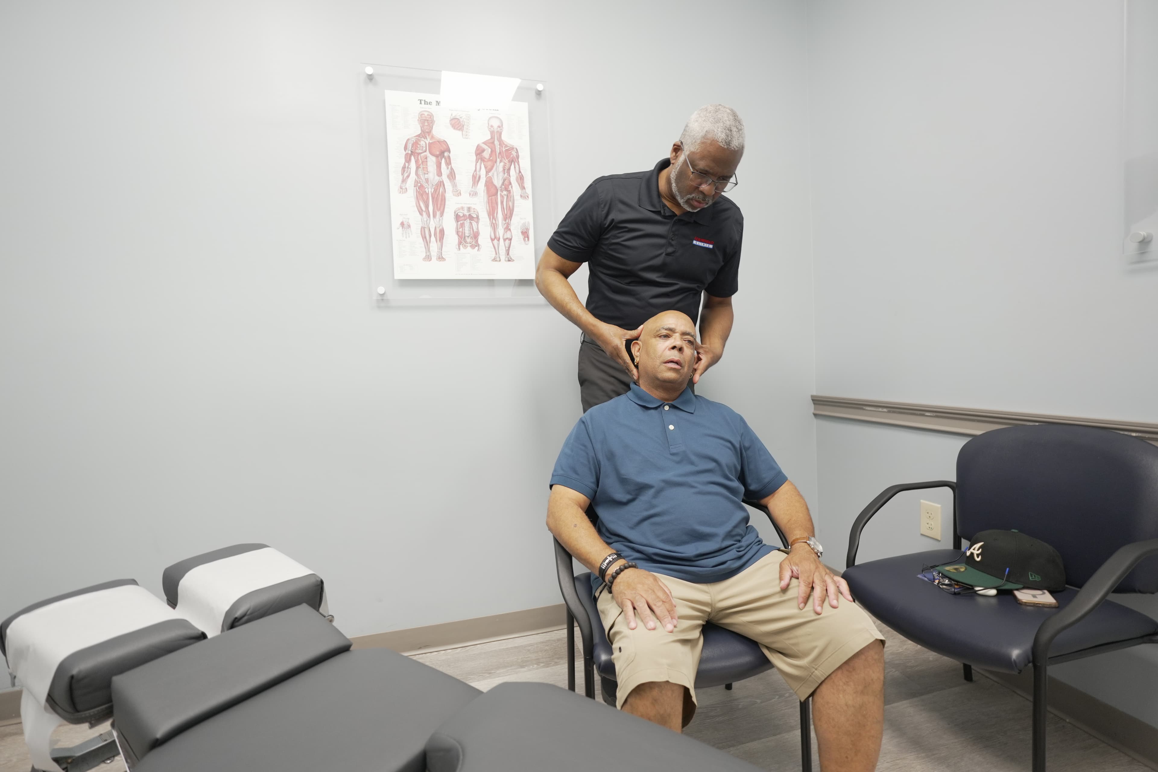 Chiropractor performing neck assessment with patient