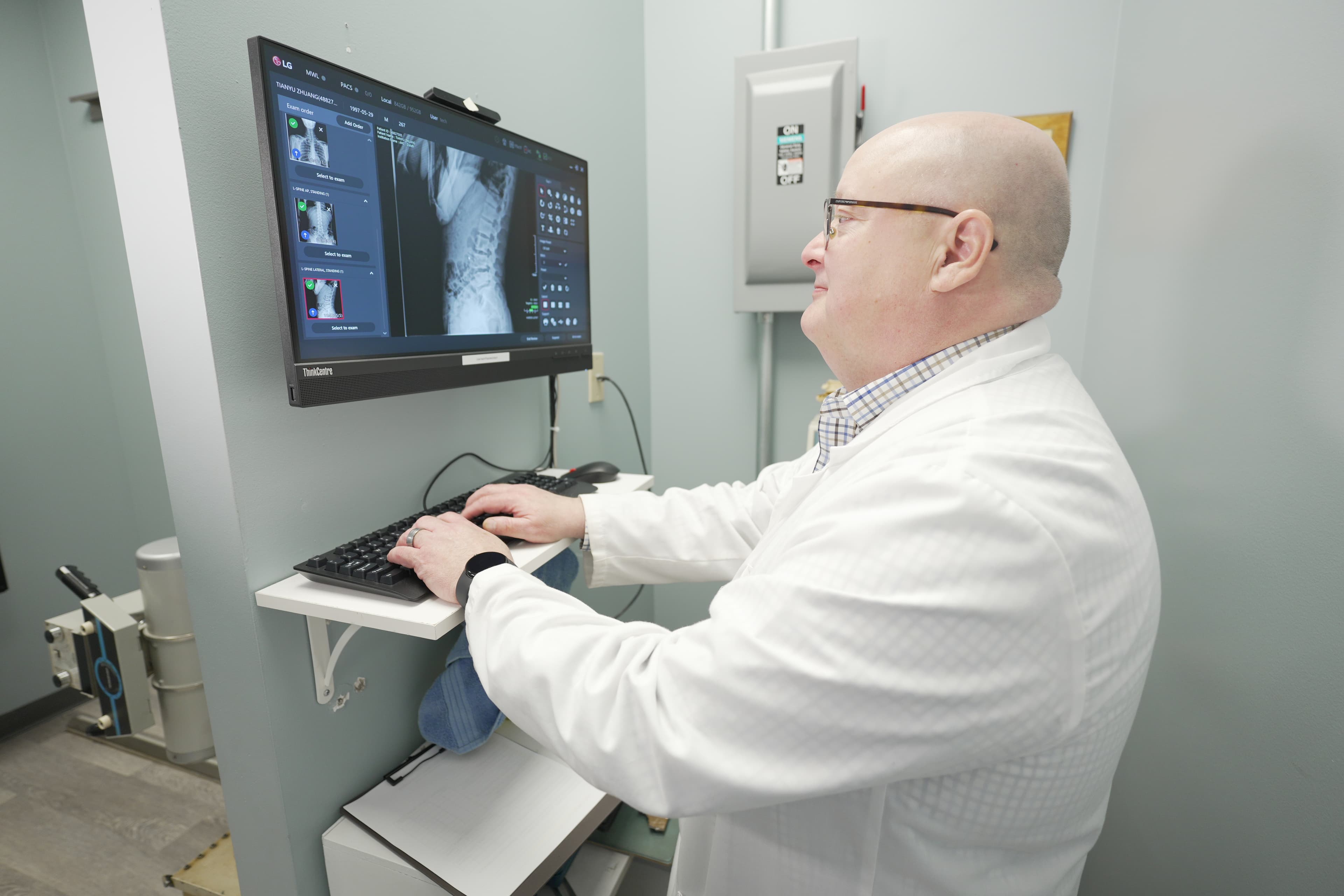 Doctor reviewing spine X-ray on monitor