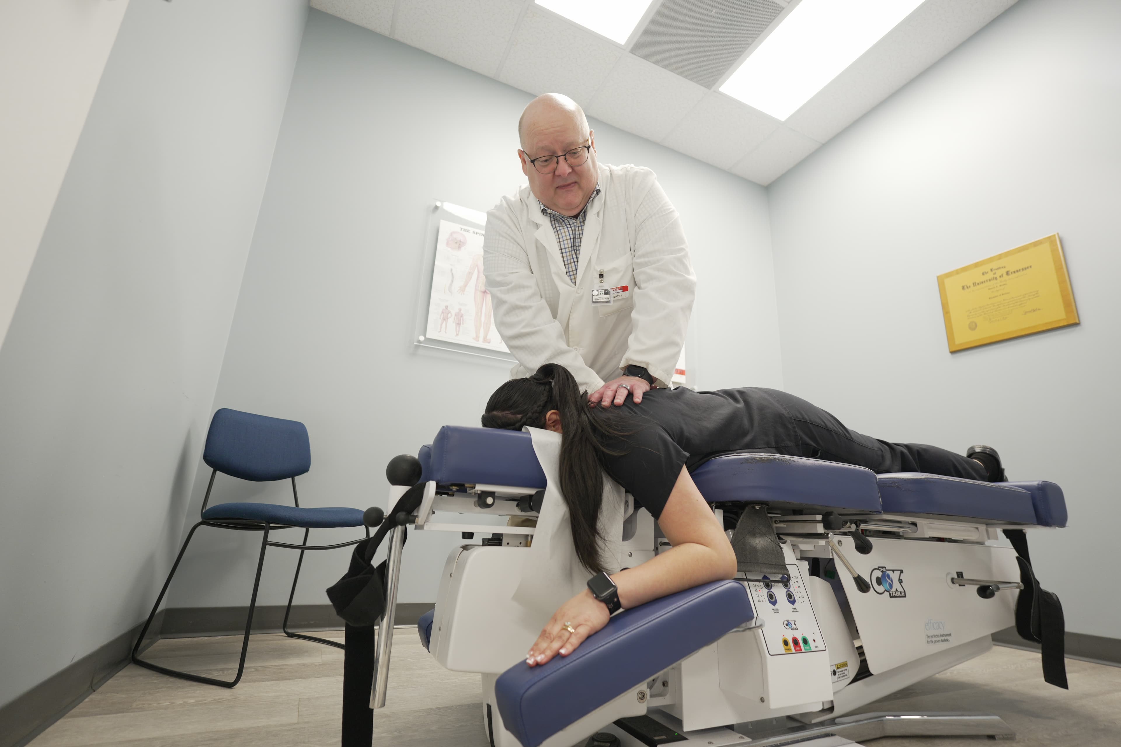 Chiropractor performing adjustment on treatment table